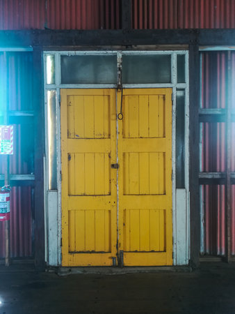 Old yellow wooden door in a warehouse at night, stock photo image New Zealandの写真素材