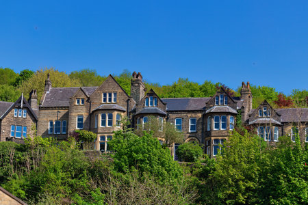 Row of traditional english houses in a row with green trees and blue skyの写真素材