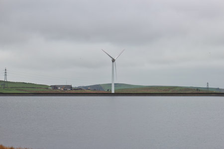 Wind turbines on the side of a lake in Heywood, Lancashire, UK