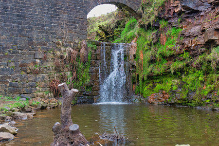 Waterfall in the old stone bridge over the river in Heywood, Lancashire, UKの写真素材