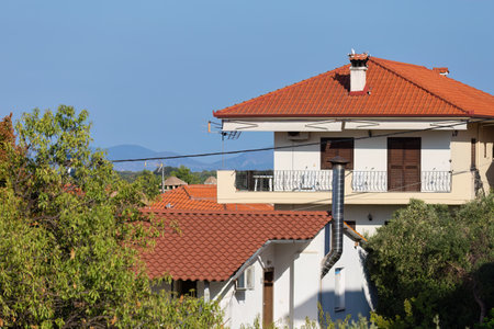 House with a red tile roof on the background of the blue sky in pefkochori, greeceの写真素材