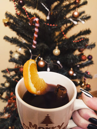 A mug of mulled wine in front of the Christmas tree