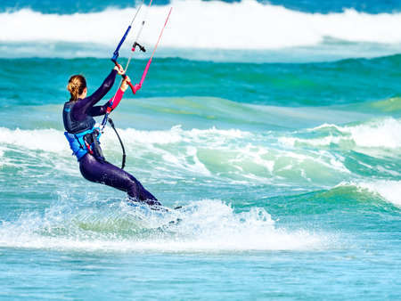 Lady kiteboarder captured kitesurfing in high wind off Kitebeach, Bloubergstrand, Table Bay, Cape...