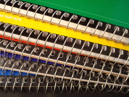 Close up of spiral bindings on notebooks.  Multi colored covers.                           の写真素材