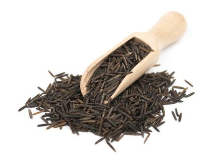 Wild black rice in wooden spoon isolated on white background
