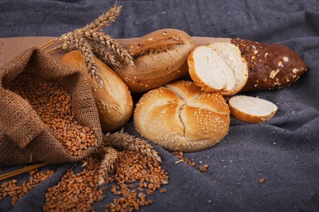 Fresh fragrant bread on the table. Food concept. Bakery, crusty loaves of bread and buns. Assortment of baked bread.の写真素材