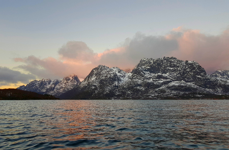 Expansive fjord in the Lofoten Islands surrounded with snowy mountains and a colorful winter sunset. Norway.の写真素材