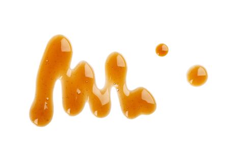 Caramel syrup drizzle isolated on white background. Splashes of sweet caramel sauce. Top viewの写真素材
