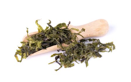 Dry wakame seaweed, isolated on white background. Sea kale, asian dry food in a wooden spoonの写真素材