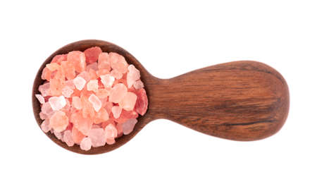 Himalayan pink salt in wooden spoon, isolated on white background. Himalayan pink salt in crystalsの写真素材