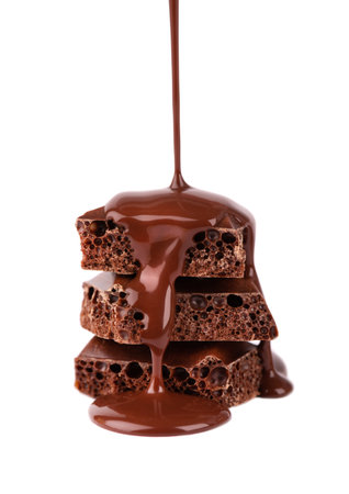 Porous chocolate pieces and chocolate syrup, isolated on white background. Black aerated chocolate.の写真素材