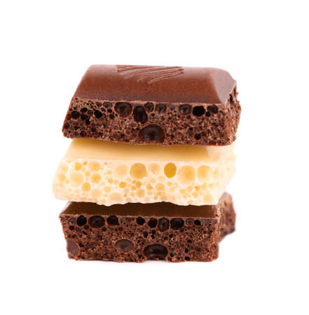 Porous chocolate pieces isolated on white background. Black and white aerated chocolate.の写真素材