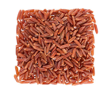 Red rice isolated on white background. Whole grain raw brown rice. Top view.の写真素材