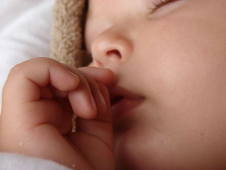 Baby sleeping whilst wrapped in warm blanketsの写真素材