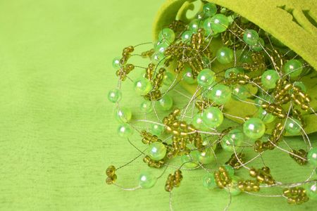 Green beadwork on a green background in a filt cupの写真素材
