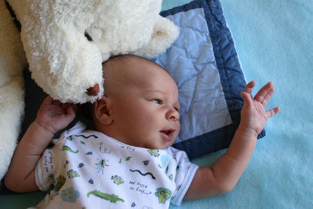 Week old baby boy on a blue blanket early in the morning