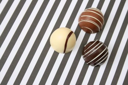 Vanilla and Dark Chocolates on a striped backgroundの写真素材