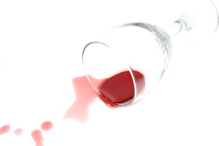 Knocked over wine glass with red wine spillの写真素材