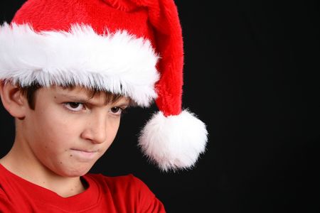 Young boy wearing a red shirt and christmas hatの写真素材
