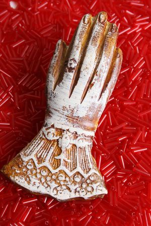 Wooden Engraved hand on a carpet of red beadsの写真素材