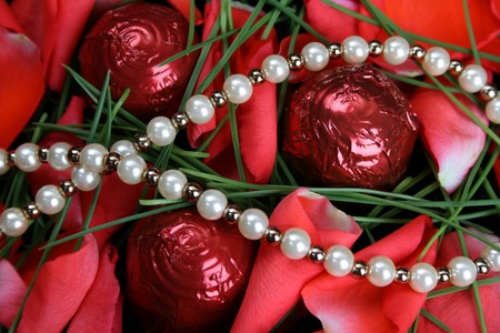 Valetines day pearls with chocolates and petalsの写真素材