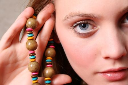Beautiful female model with blue eyes and a string beadsの写真素材