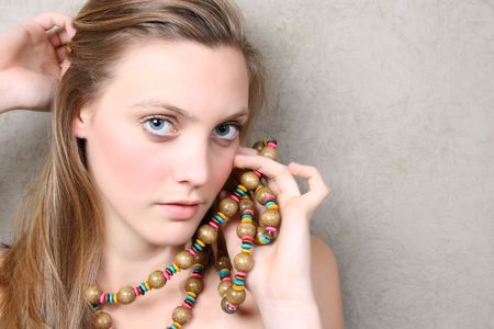 Beautiful female model with blue eyes and a string beadsの写真素材