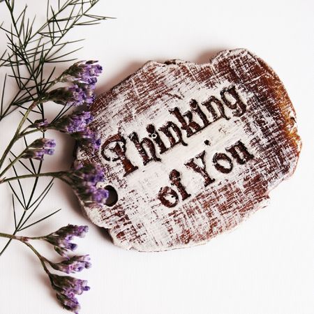 The words Thinking Of You engraved on a small wooden plaqueの写真素材