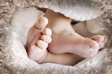 New Born Baby feet in a white blanketの写真素材