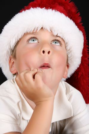 Cute christmas boy with beautiful blue eyes looking upの写真素材