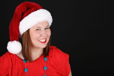 Cheerful young brunette wearing a red top and christmas hatの写真素材
