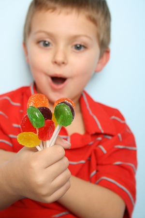 Beautiful blond boy with hand full of lolliesの写真素材