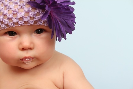 Beautiful baby girl wearing a headband with purple flowerの写真素材