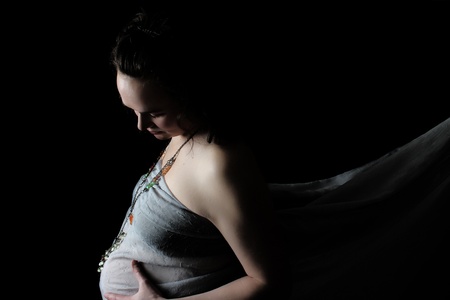 Beautiful pregnant lady against a black backgroundの写真素材