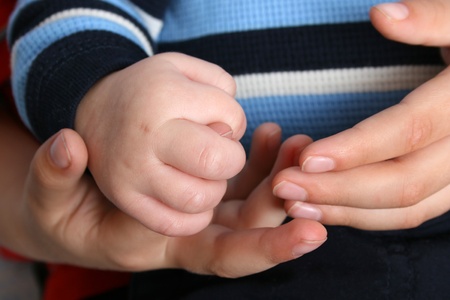 Young boy holding his baby brothers handsの写真素材
