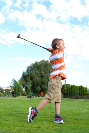 Young golfer playing a shot from the fairwayの写真素材