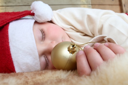 Beautiful sleeping christmas baby boy on soft rugの写真素材
