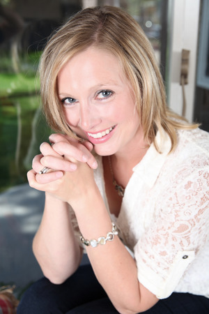 Portrait shot of beautiful blond woman against a windowの写真素材