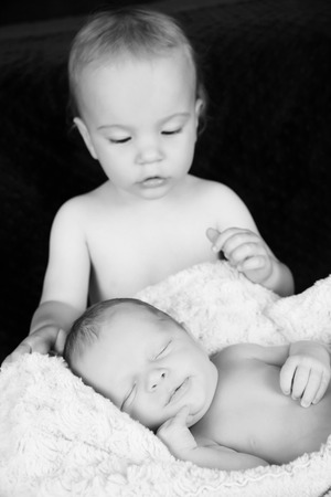 Toddler boy with his newborn baby brotherの写真素材