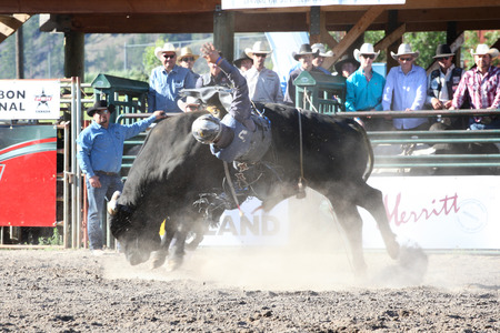 MERRITT, B.C. CANADA - May 30, 2015: Bull rider riding in the first round of The 3rd Annual Ty Pozzobon Invitational PBR Event.のeditorial素材