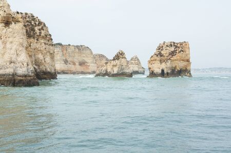 seascape with rocky cliffs in the lagos in southern portugalの写真素材