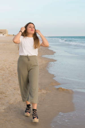 portrait of a beautiful young woman walking on the beachの写真素材