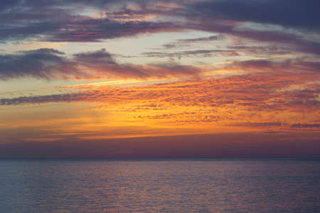 beautiful and colorful sunset in the sea full of cloudsの写真素材