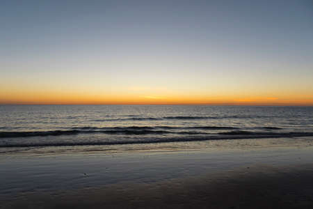 a beautiful and colorful sunset on the beachの写真素材