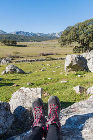 shot of the legs of a seated hiker in a beautiful nature landscape with the mountains in the background in the south of spainの写真素材