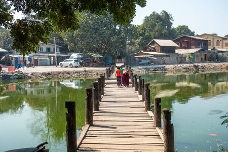 Children walking over teak wood bridgeの写真素材