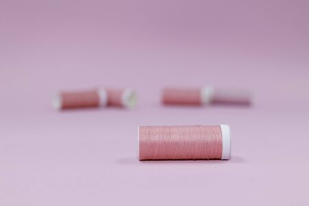 Sewing threads, pink spools of thread on a pink background. Room for copy.の写真素材