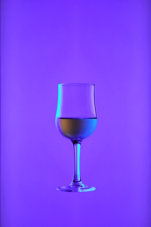 Goblet with white wine on blue background. の写真素材