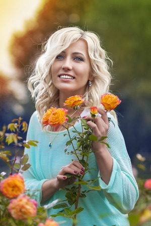 beauty woman with roses in parkの写真素材