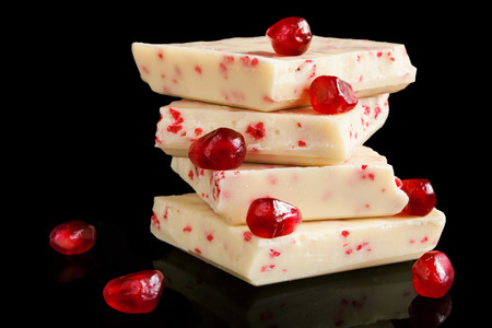White chocolate with red berries on black background.の写真素材